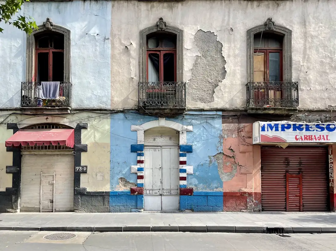 Locales comerciales con las cortinas metálicas cerradas en una calle de México