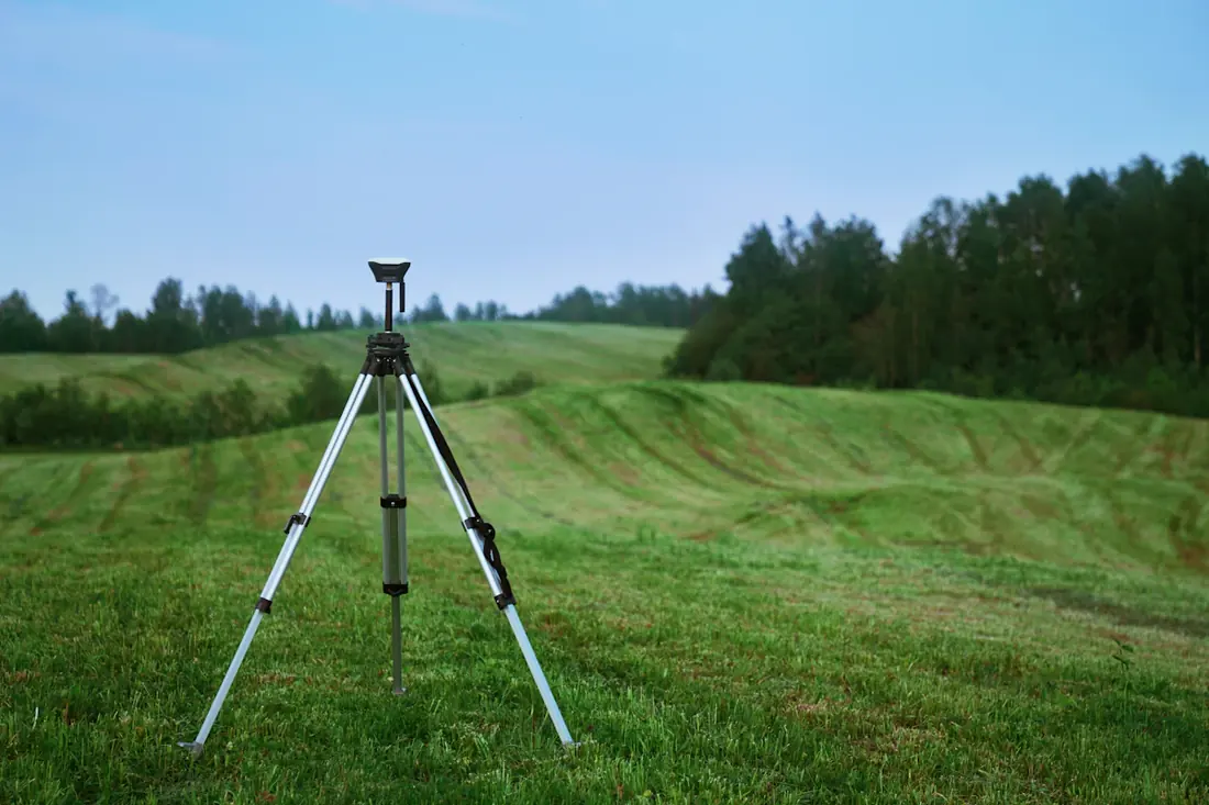Equipo de topografía instalado en un terreno de cultivo para medir sus límites
