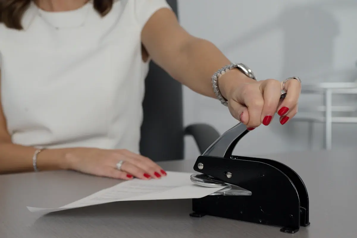 Persona sella un documento con un sello de relieve